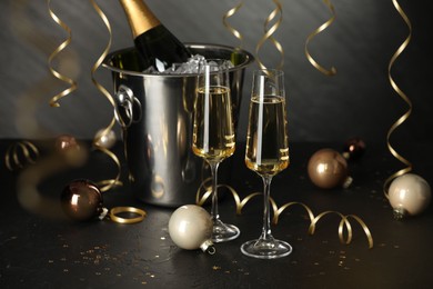 Photo of Champagne in glasses and decor on black table. Christmas celebration