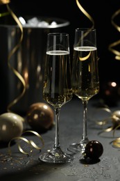 Photo of Champagne in glasses and decor on grey table. Christmas celebration