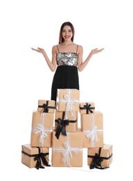 Woman in party dress with Christmas gifts on white background