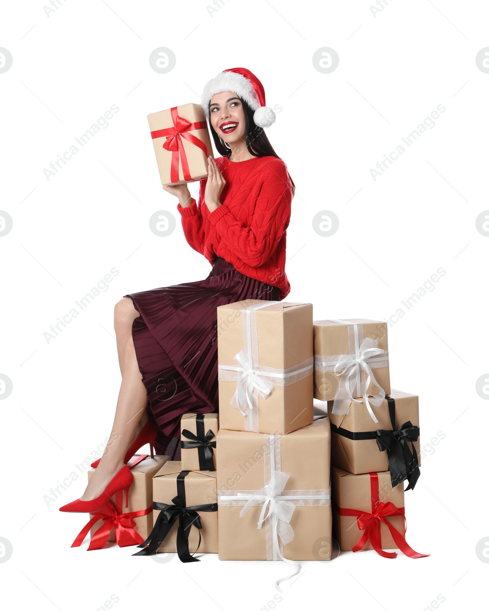 Photo of Woman in red sweater and Santa hat with Christmas gifts on white background