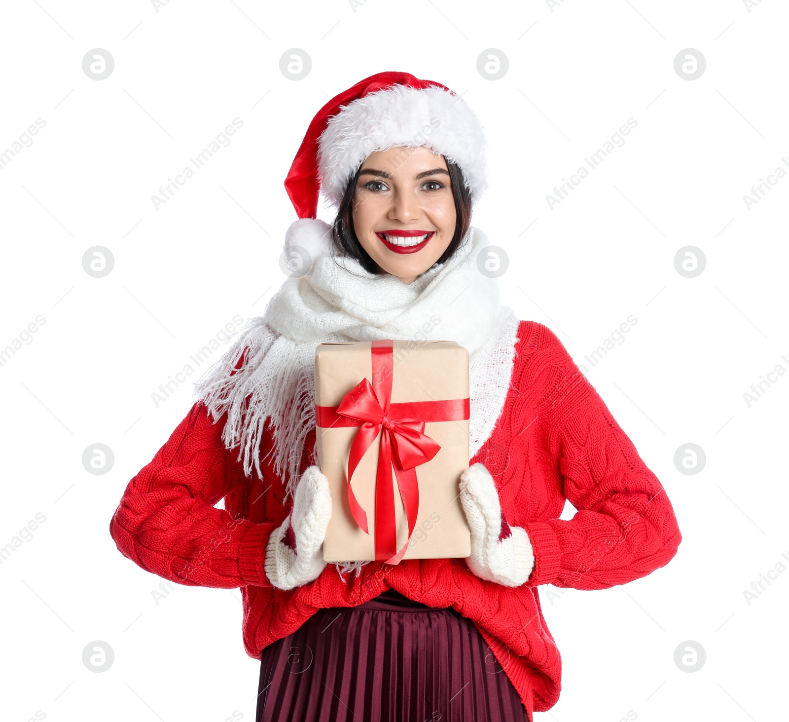 Photo of Woman in Santa hat, knitted mittens, scarf and red sweater holding Christmas gift on white background