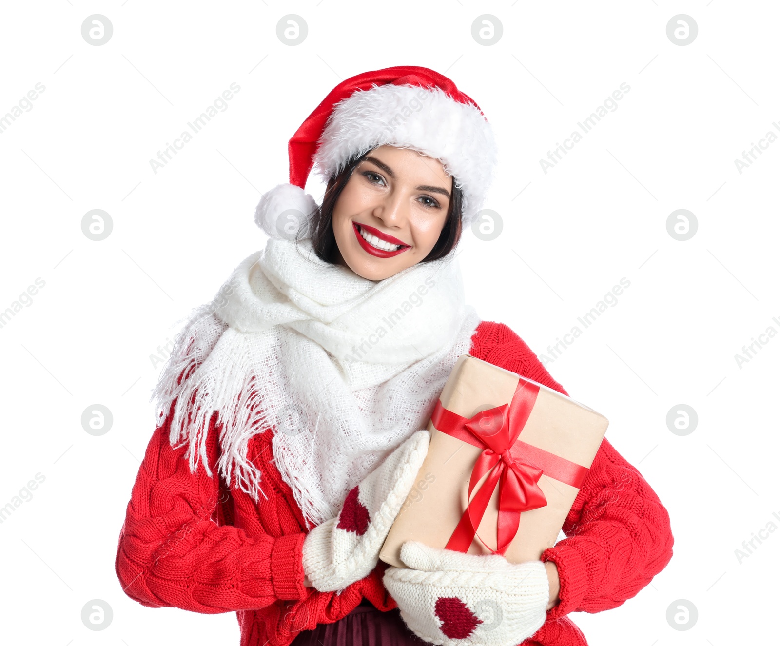 Photo of Woman in Santa hat, knitted mittens, scarf and red sweater holding Christmas gift on white background