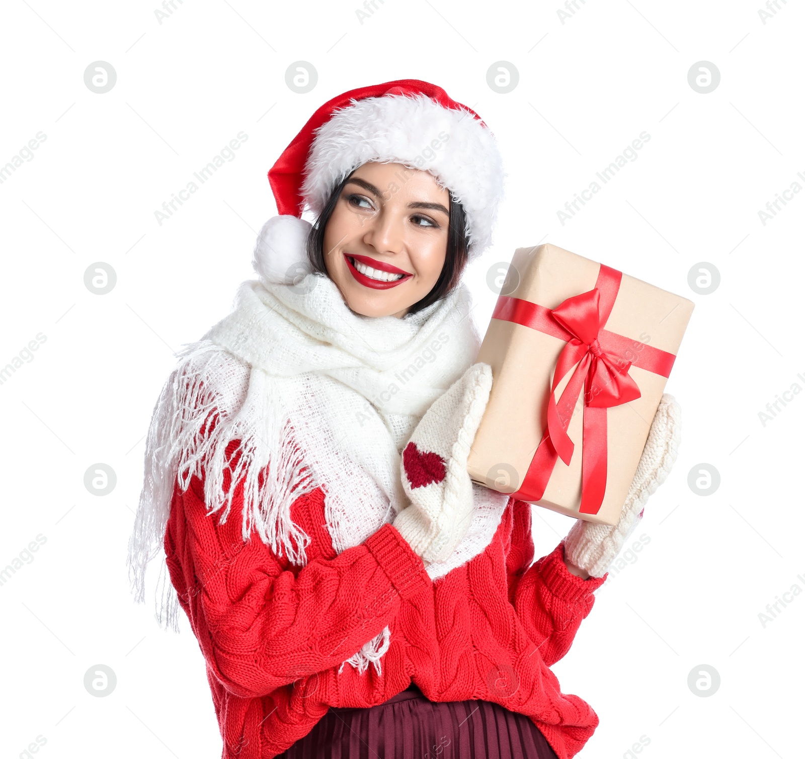 Photo of Woman in Santa hat, knitted mittens, scarf and red sweater holding Christmas gift on white background