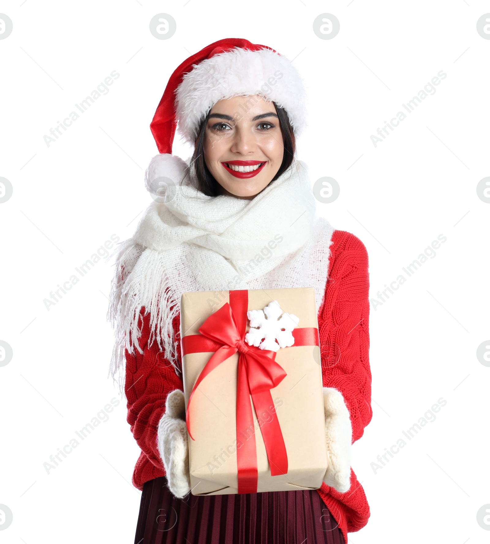 Photo of Woman in Santa hat, knitted mittens, scarf and red sweater holding Christmas gift on white background