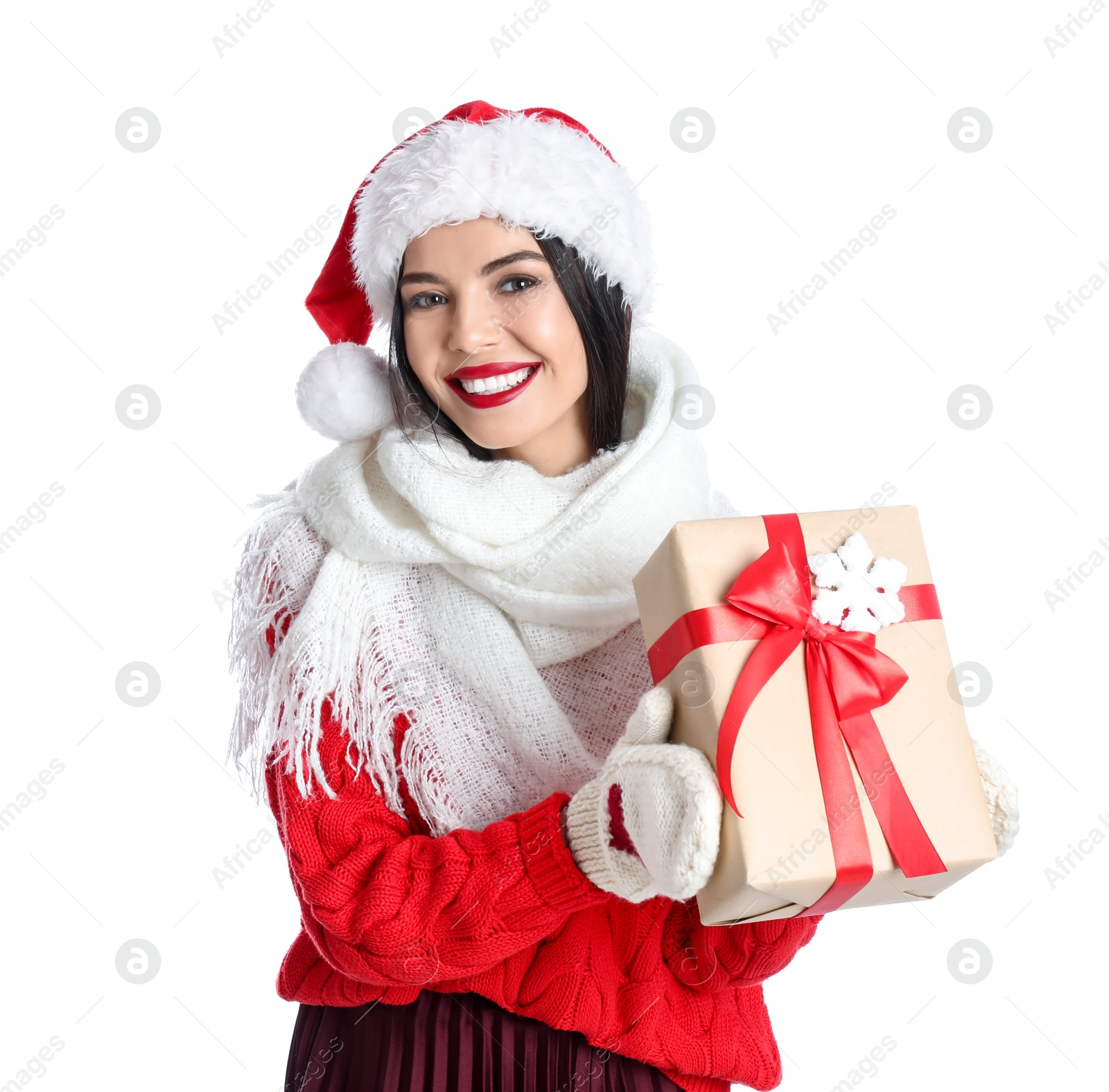 Photo of Woman in Santa hat, knitted mittens, scarf and red sweater holding Christmas gift on white background