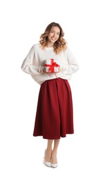 Beautiful young woman with Christmas present on white background