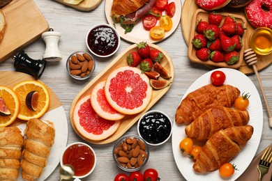 Photo of Different tasty food served for brunch on wooden table, flat lay