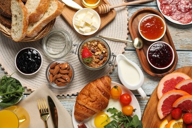 Photo of Different tasty food served for brunch on white wooden table, flat lay