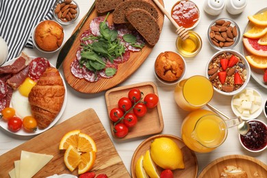 Photo of Different tasty food served for brunch on white wooden table, flat lay