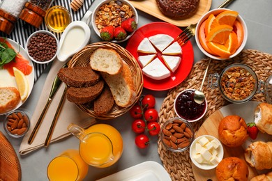 Photo of Different tasty food served for brunch on grey table, flat lay