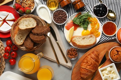 Photo of Different tasty food served for brunch on grey table, flat lay