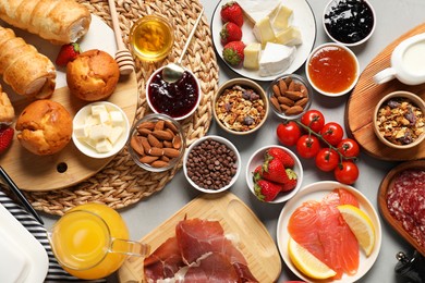 Photo of Different tasty food served for brunch on grey table, flat lay