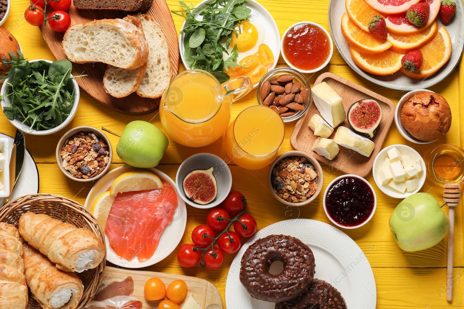 Photo of Different tasty food served for brunch on yellow wooden table, flat lay