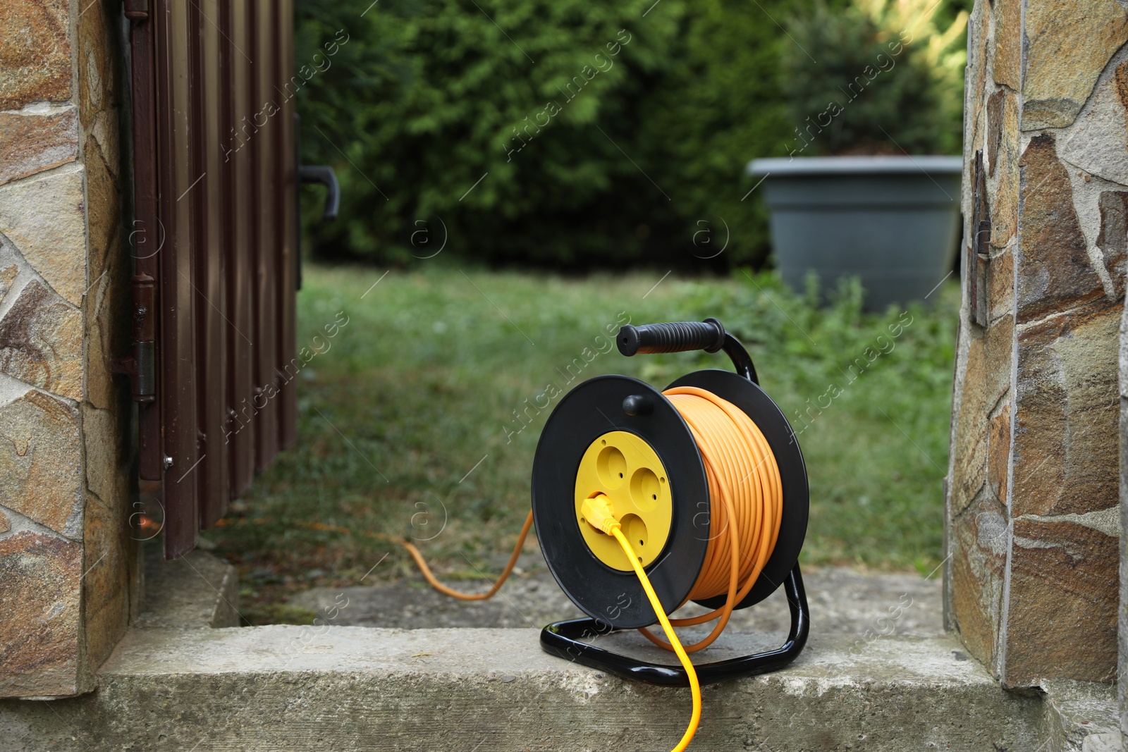 Photo of Extension cord reel in backyard. Electrician's equipment