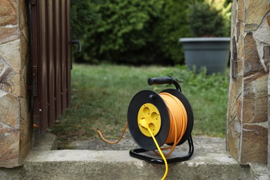 Photo of Extension cord reel in backyard. Electrician's equipment