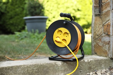 Photo of Extension cord reel in backyard. Electrician's equipment