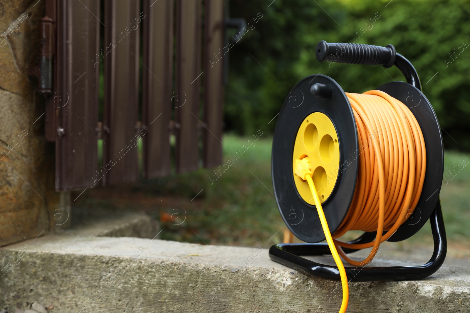 Photo of Extension cord reel in backyard. Electrician's equipment