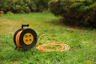 Photo of Extension cord reel on green grass outdoors