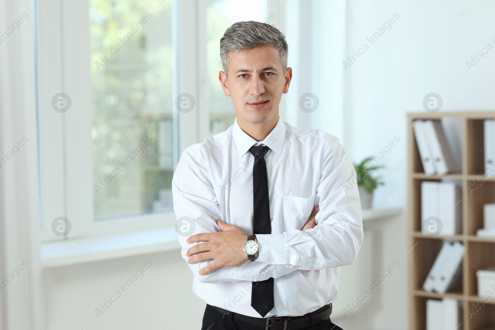 Photo of Portrait of businessman with crossed arms in office