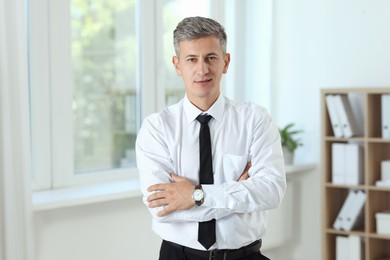 Portrait of businessman with crossed arms in office