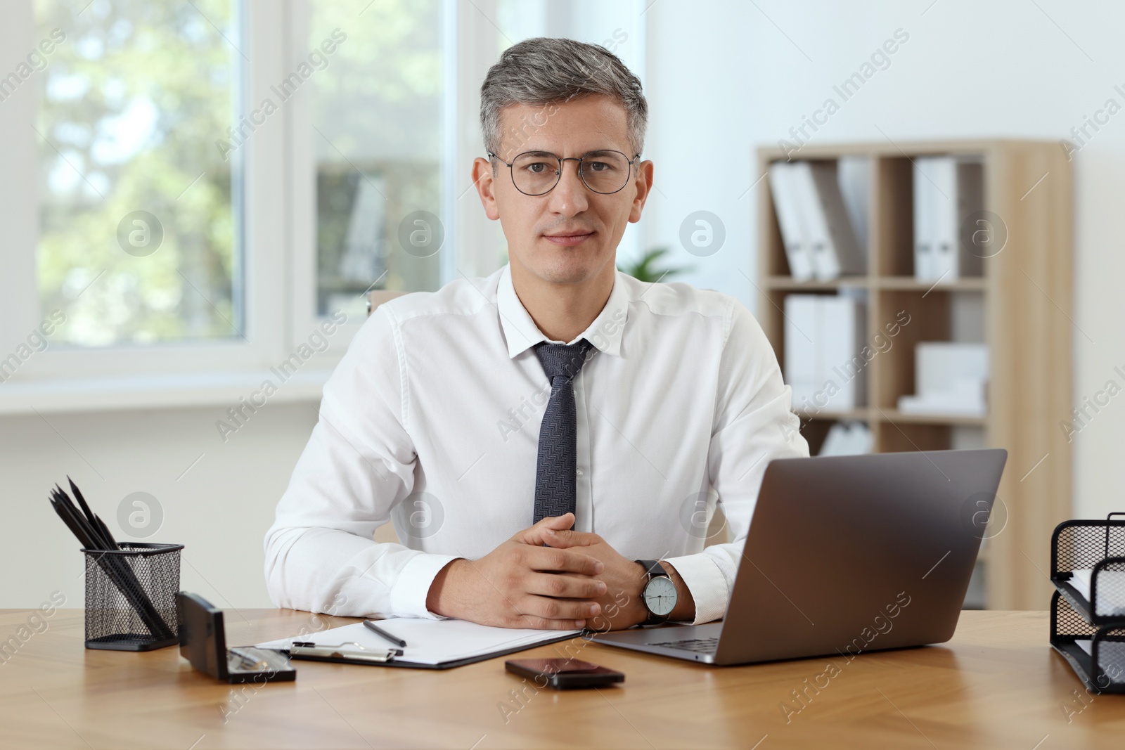 Photo of Portrait of businessman at table in office