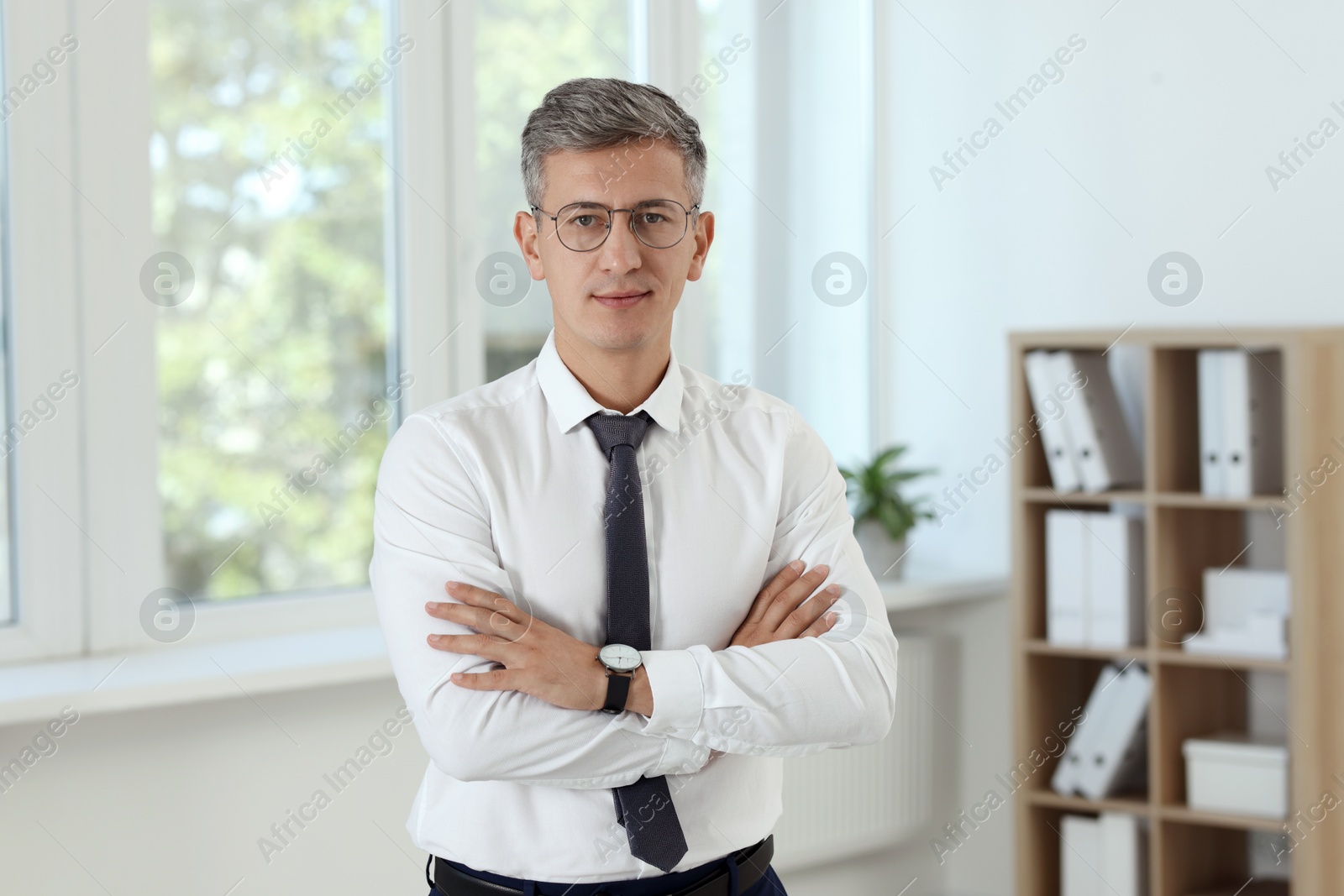 Photo of Portrait of businessman with crossed arms in office