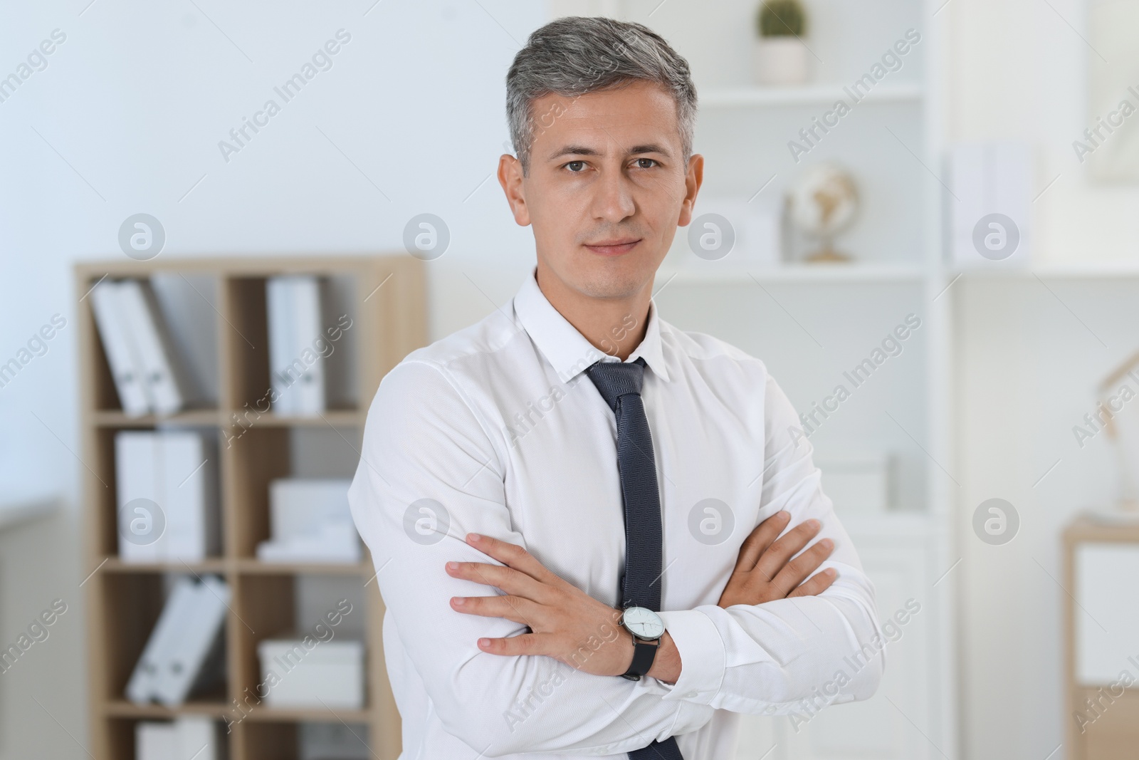 Photo of Portrait of businessman with crossed arms in office