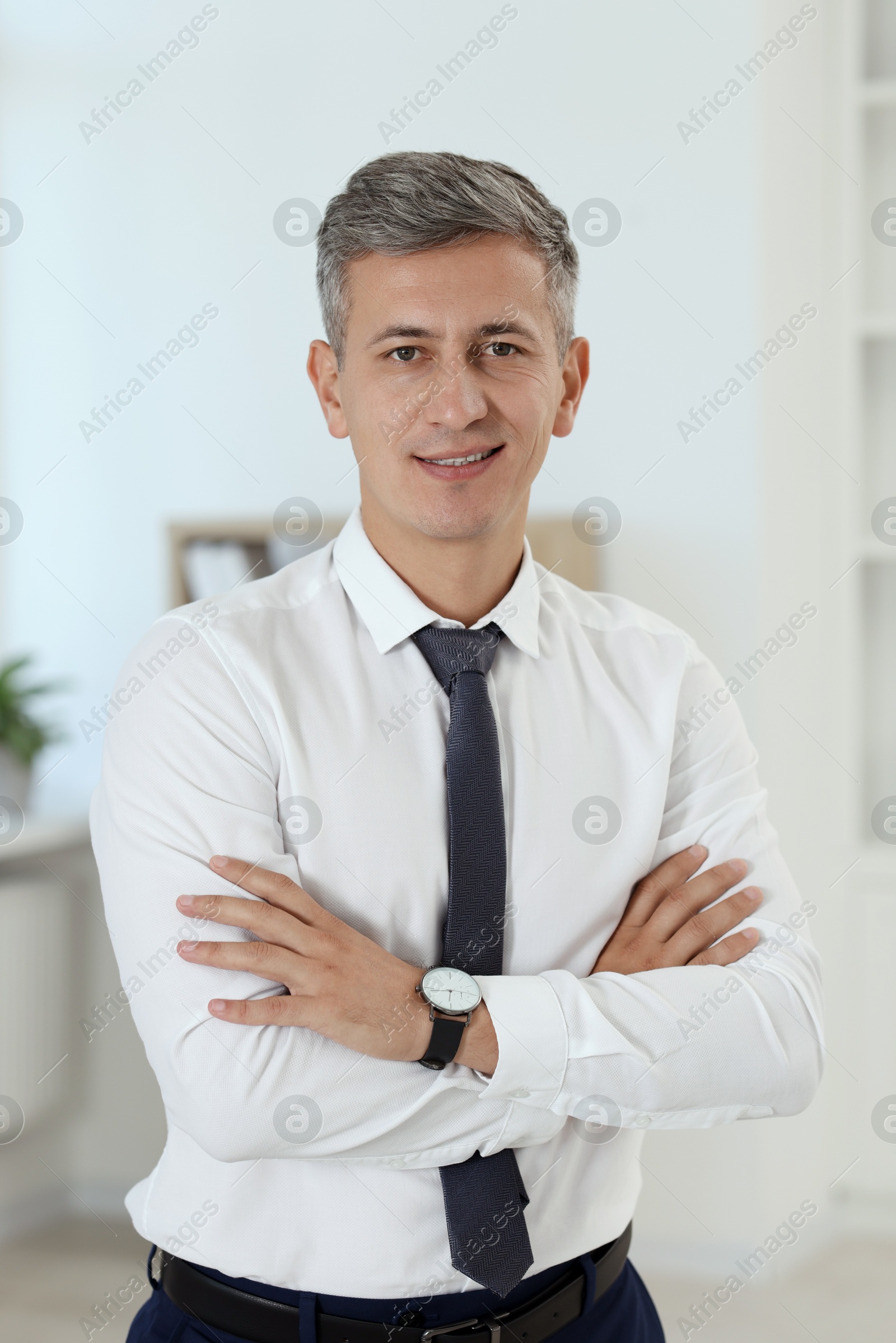 Photo of Portrait of businessman with crossed arms in office