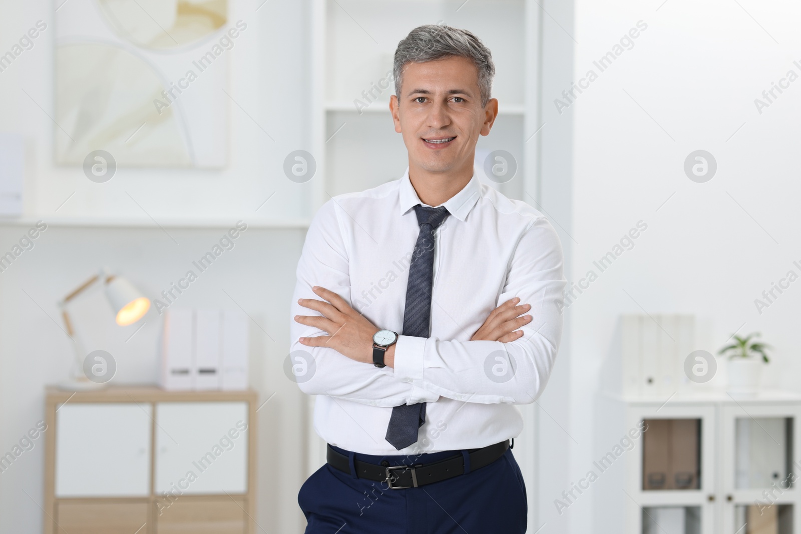 Photo of Portrait of businessman with crossed arms in office