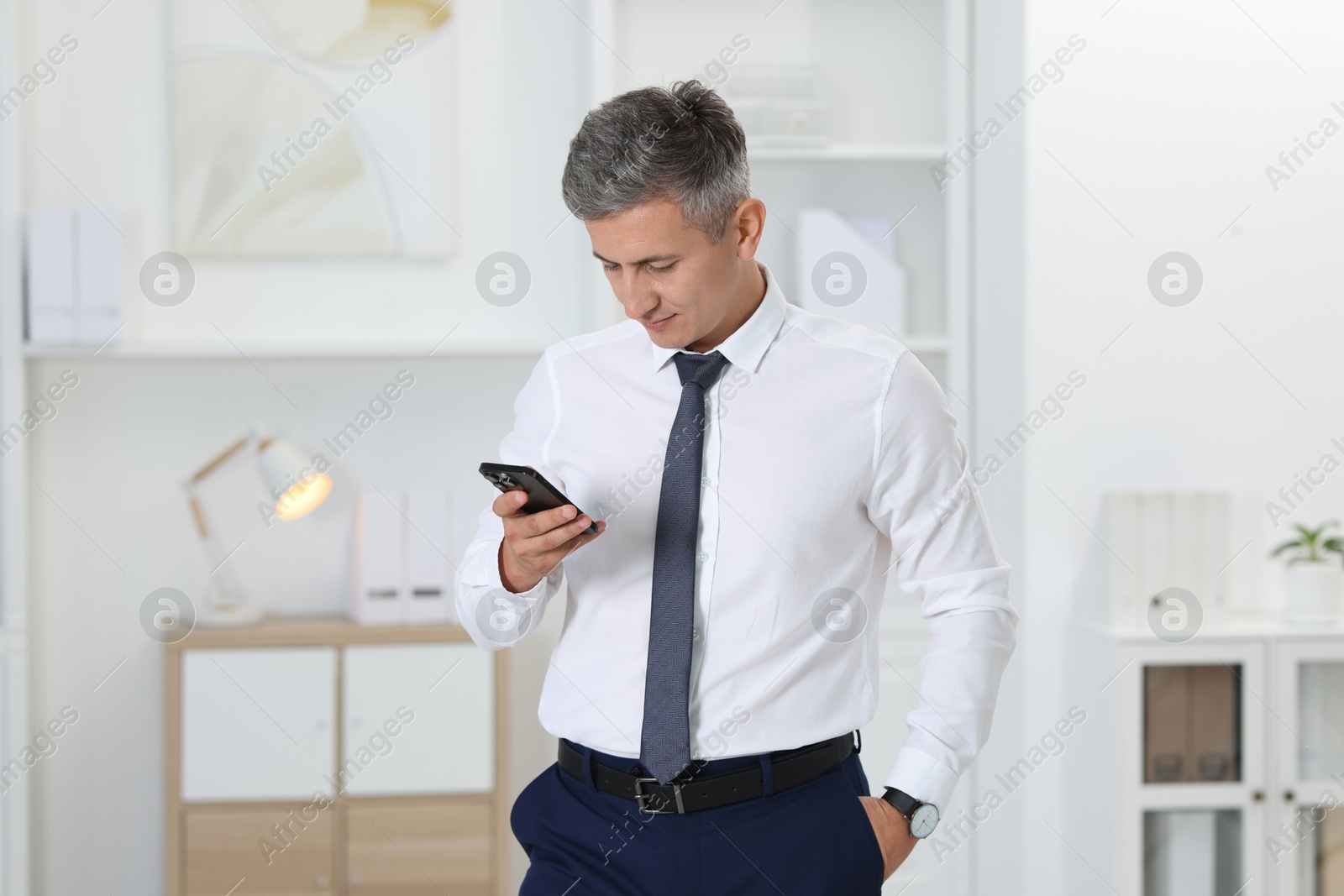 Photo of Portrait of businessman using smartphone in office