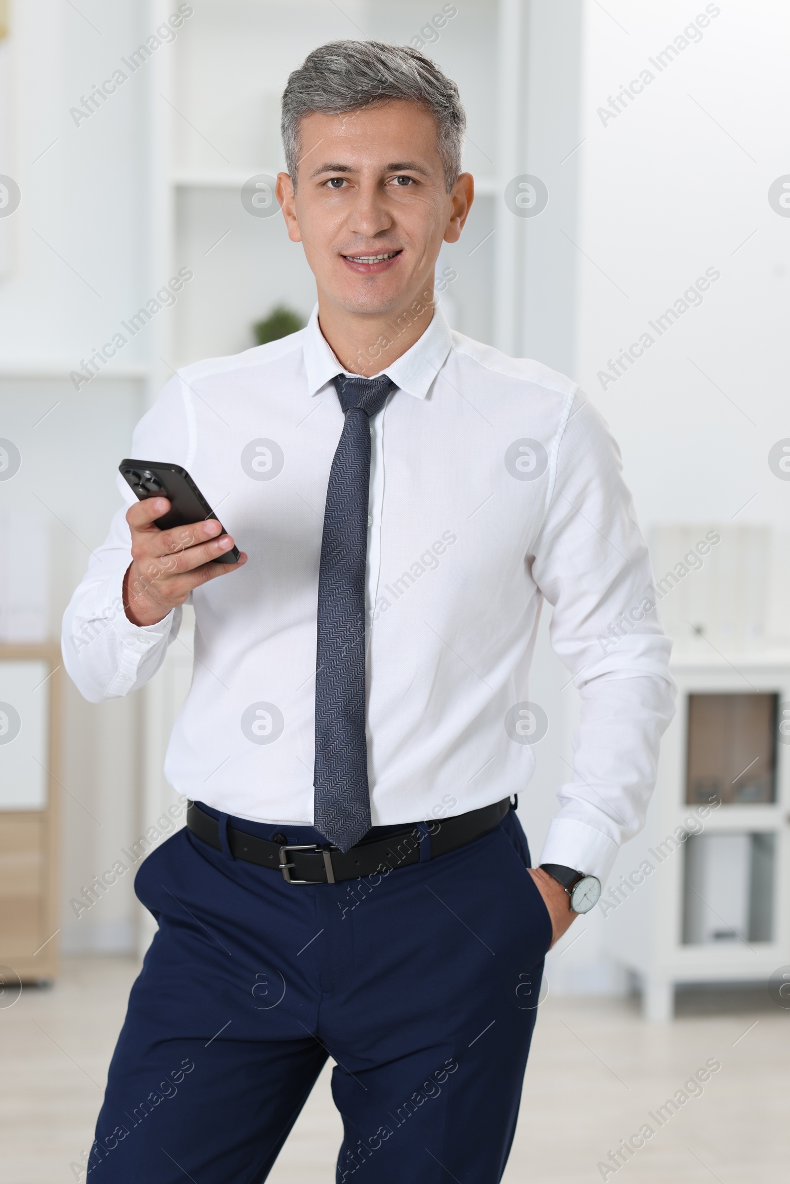 Photo of Portrait of businessman using smartphone in office