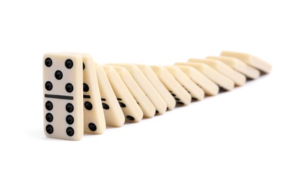 Photo of Domino effect. Tiles falling on white background