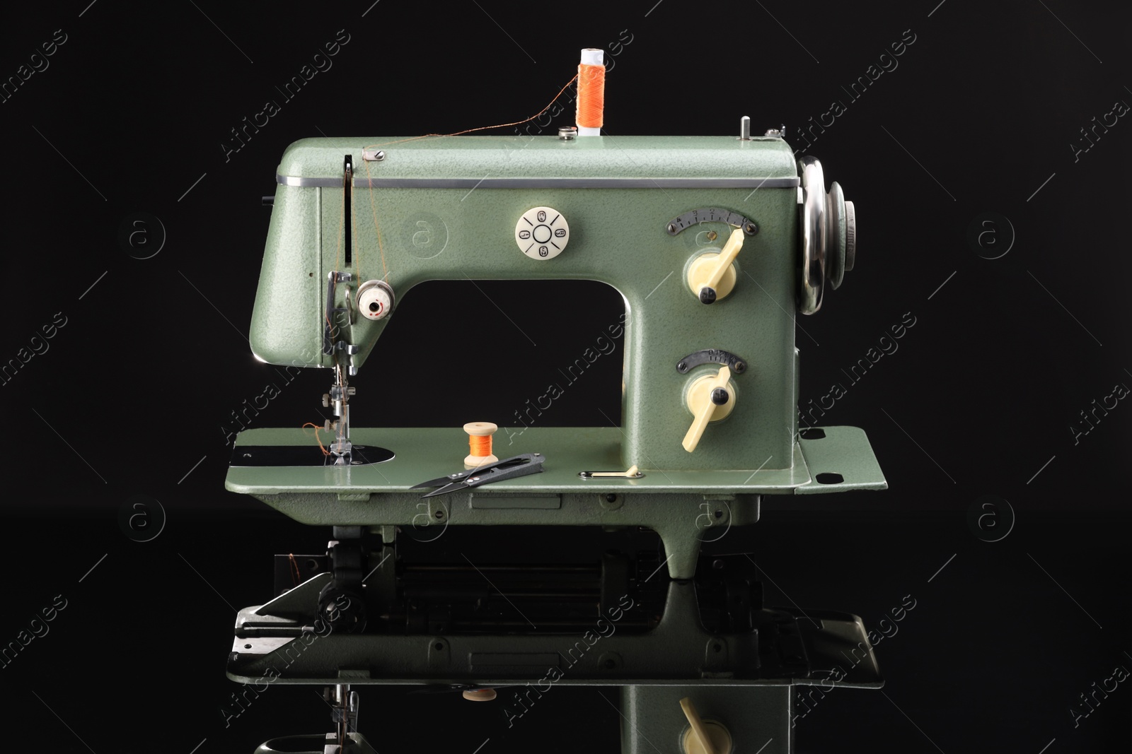 Photo of Vintage professional sewing machine on black background