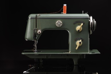 Photo of Vintage professional sewing machine on black background