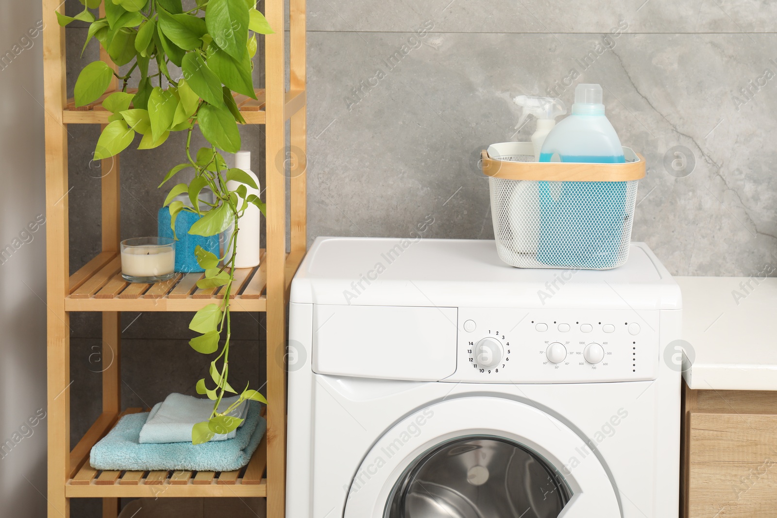 Photo of Laundry detergents in basket on washing machine indoors