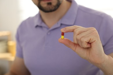 Photo of Man with pill at home, closeup on hand