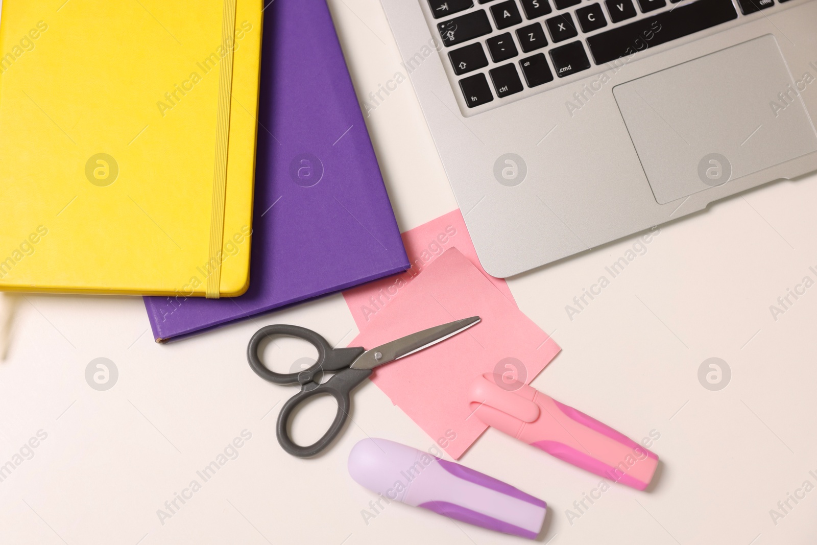 Photo of Designer's workplace with laptop and stationery on white table, flat lay