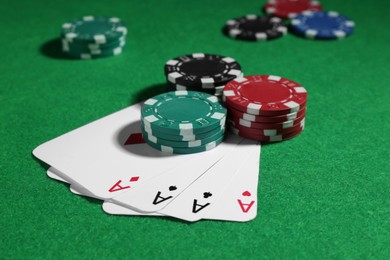 Photo of Playing cards and poker chips on green table