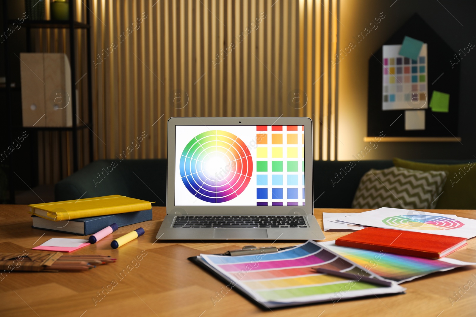 Photo of Designer's workplace with laptop, stationery and palettes on wooden table indoors