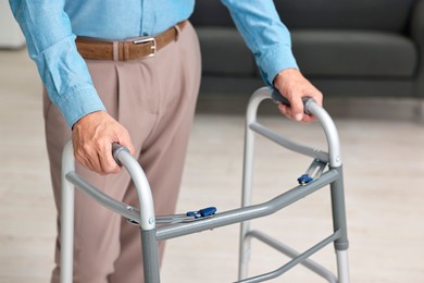 Photo of Senior man using walking frame at home, closeup