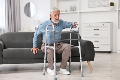 Senior man with walking frame on sofa at home