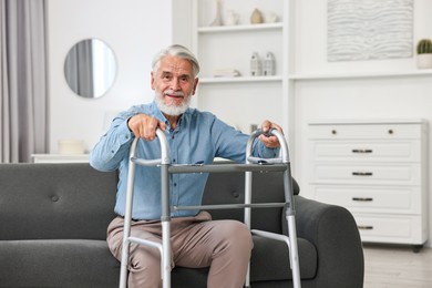 Photo of Senior man with walking frame on sofa at home