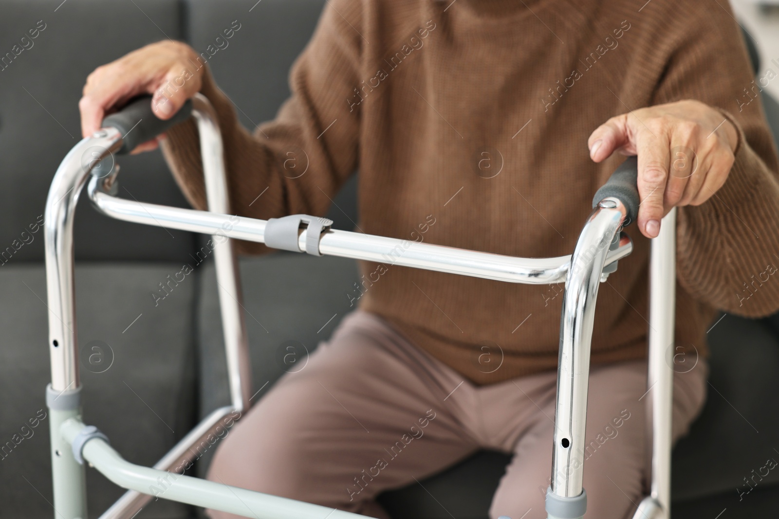 Photo of Senior man with walking frame on sofa at home, closeup