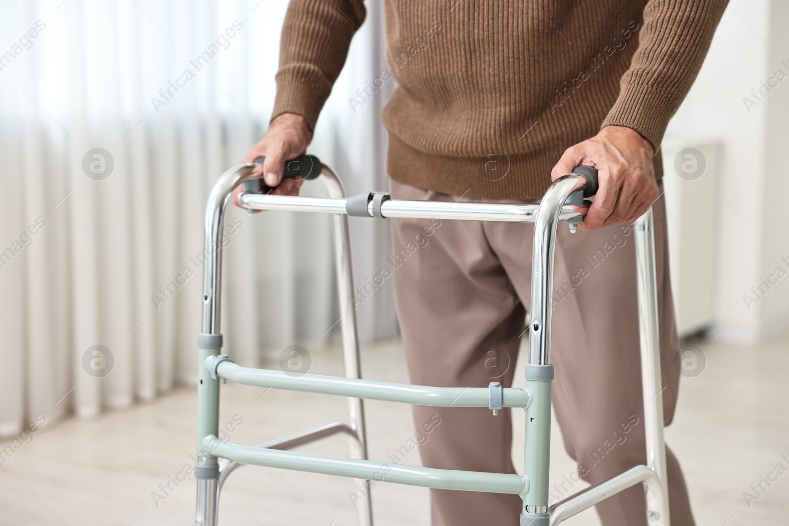 Photo of Senior man using walking frame at home, closeup