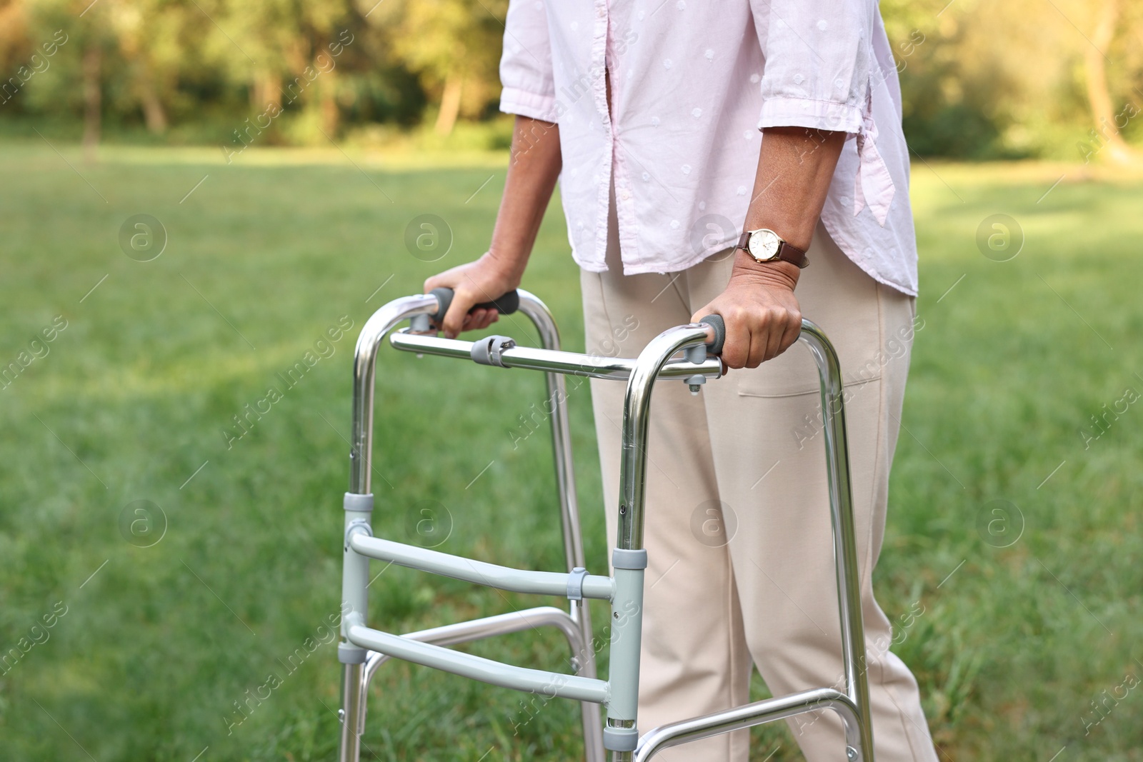 Photo of Senior woman with walking frame in park, closeup