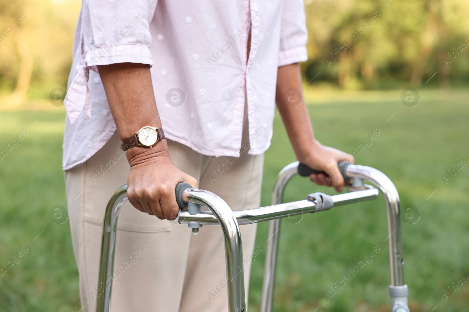 Photo of Senior woman with walking frame in park, closeup