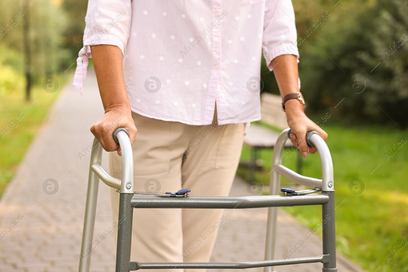 Photo of Senior woman with walking frame in park, closeup