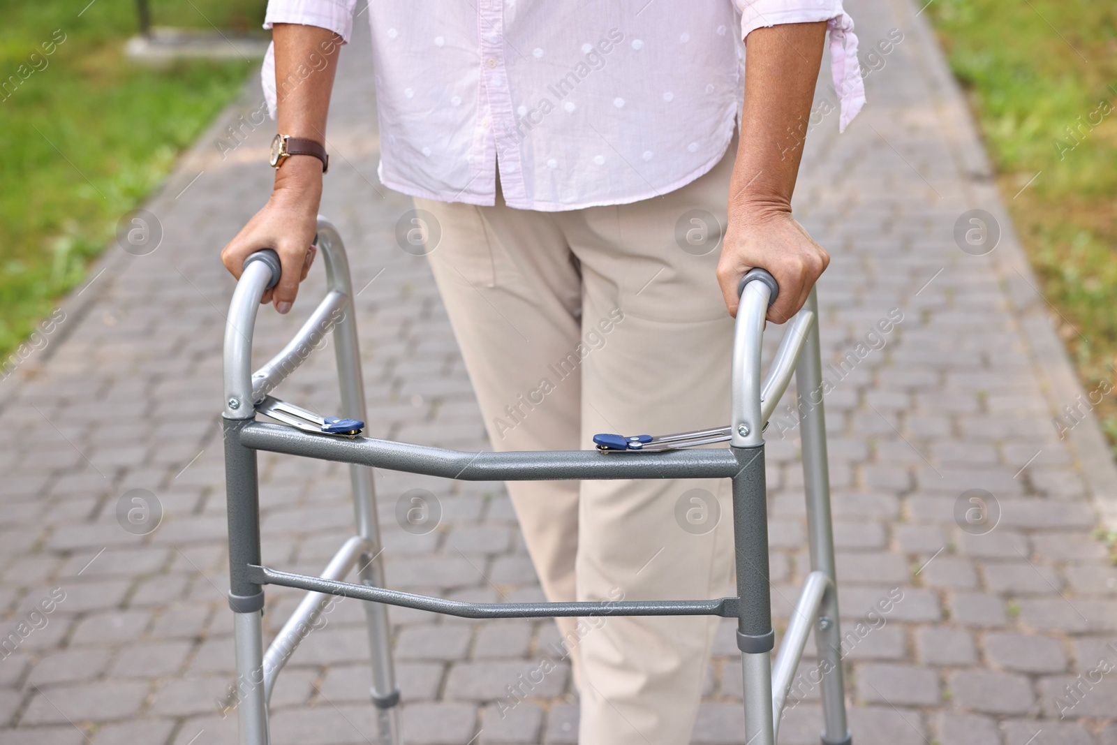 Photo of Senior woman with walking frame in park, closeup