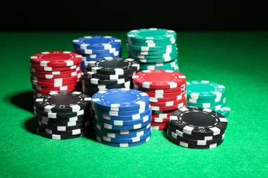 Photo of Poker game. Casino chips on green table, closeup