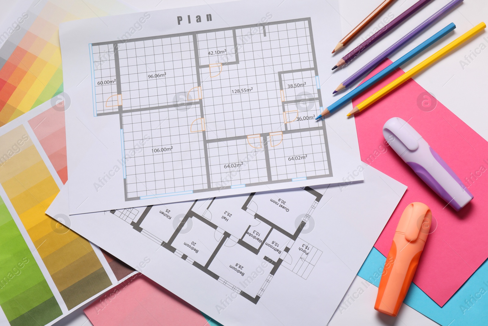 Photo of Designer's workplace with house plans, color palettes and stationery on table, top view